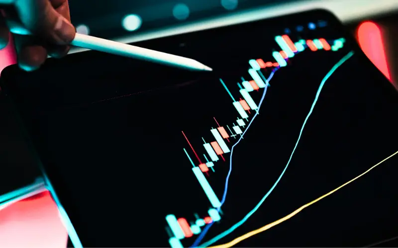 How U.S. Finance CIOs Build Governance for Sustainable Growth 2025 1 “Digital candlestick chart on a tablet with a stylus pointing at rising financial data, symbolizing innovation, analytics, and growth in the U.S. finance sector.